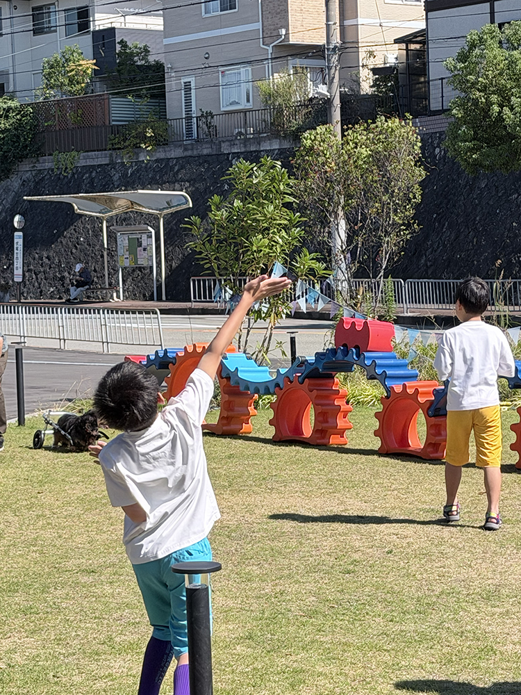 芝生の上で元気いっぱい竹とんぼを飛ばす子供