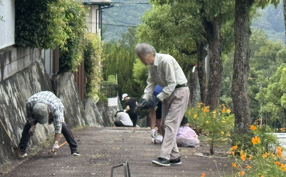 郵便局前の歩道を掃除する人々