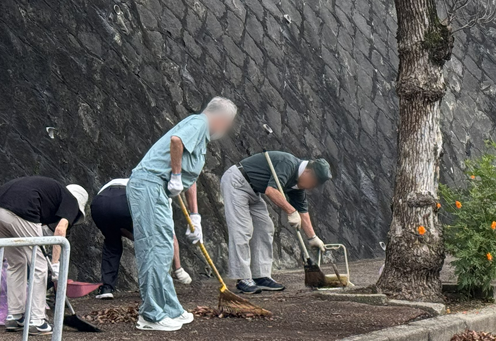 5丁目のバス停前を掃除する住民