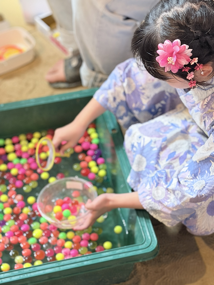 ピンポン玉すくいする浴衣の少女