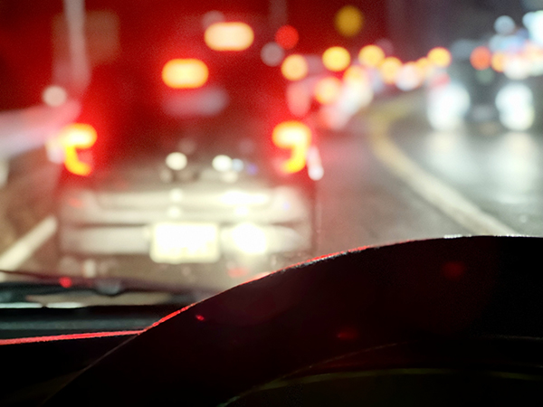 夜の車の運転。テールランプがずらりと並んだ渋滞につかまる