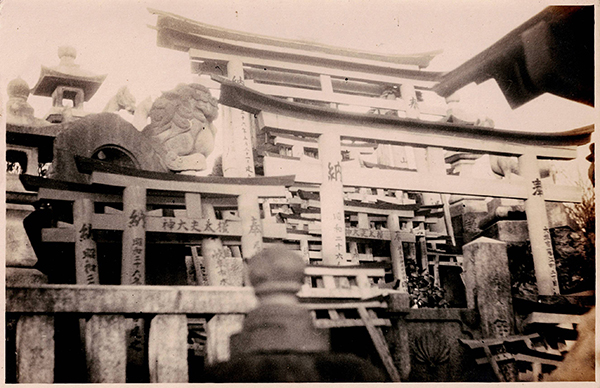 モノクロ写真　祠の前に小さいサイズの鳥居を奉納する写真